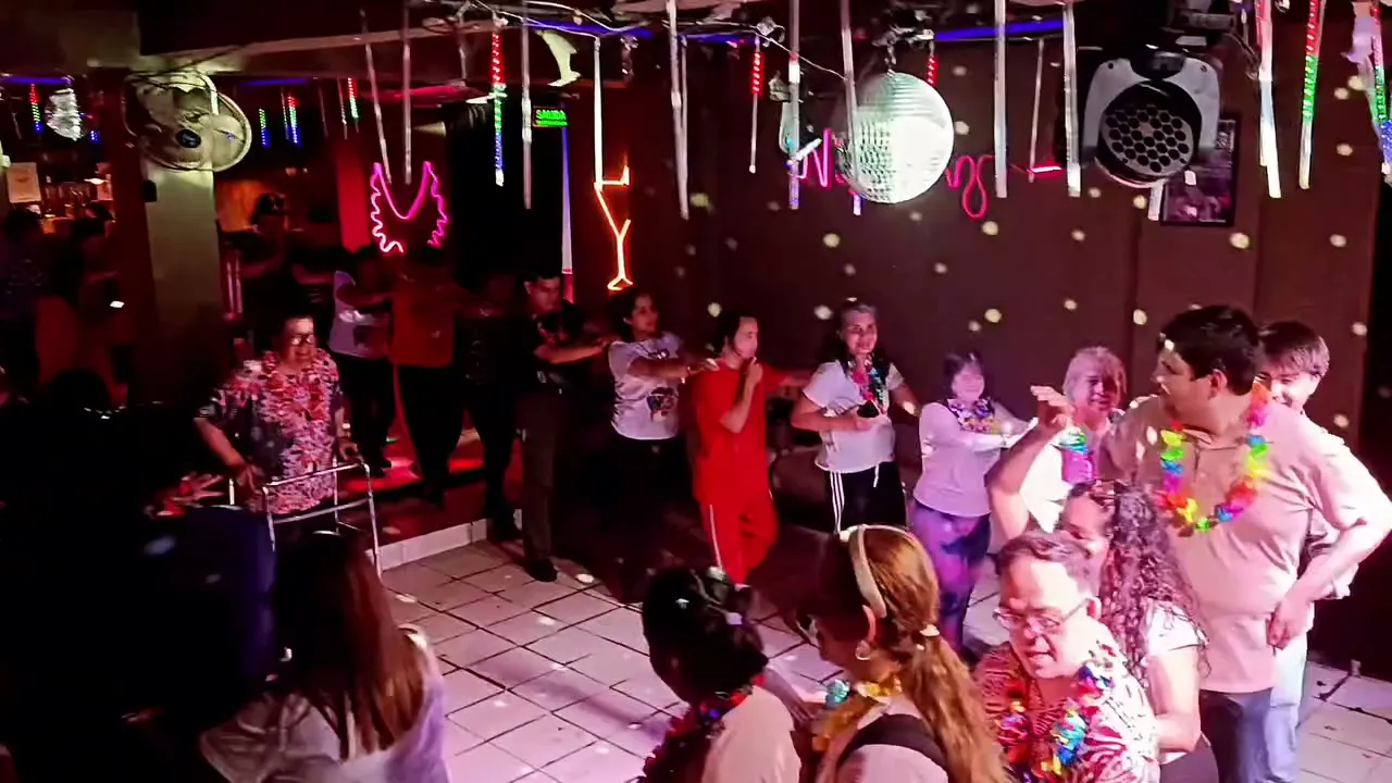 Grupo bailando en ronda durante la Fiesta de las Flores, con collares de flores de colores